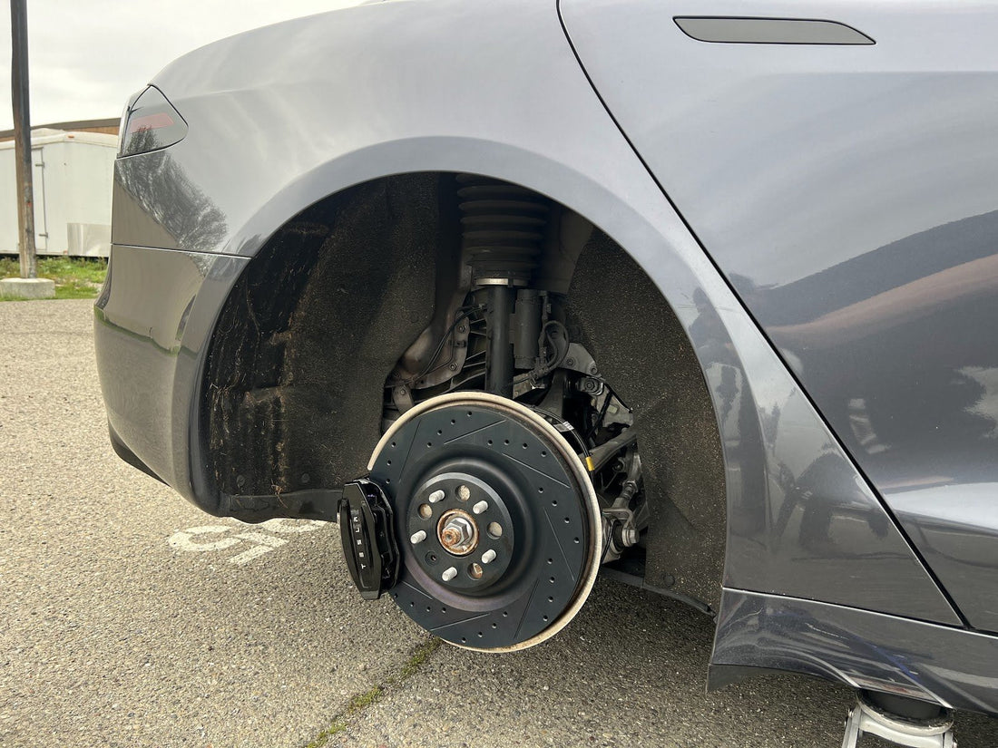 Gray Tesla Model S with the rear wheel removed showing the brake rotor and caliper during a mobile Bay Area brake inspection