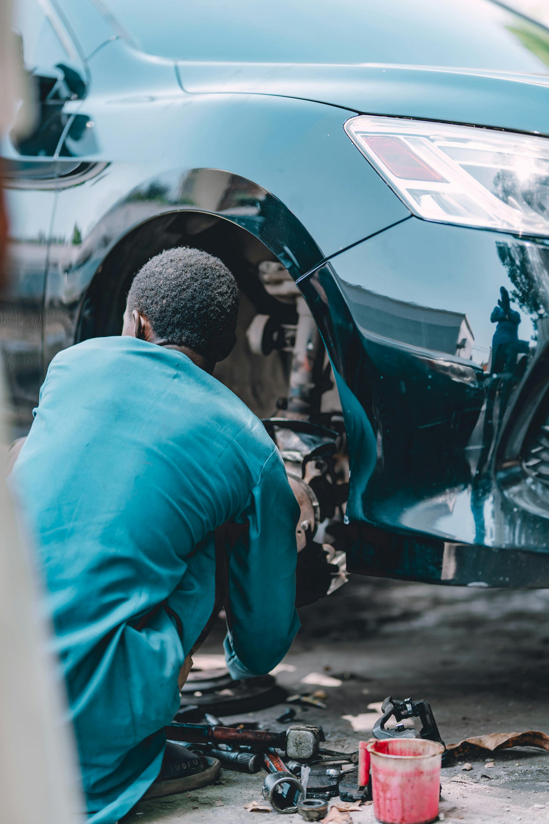 Mobile mechanic working on a car in a driveway