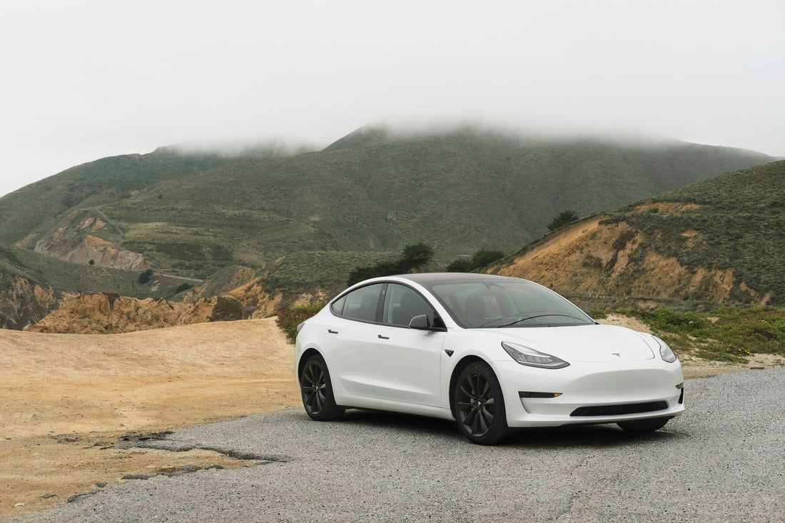 White Tesla Model 3 parked on a scenic road