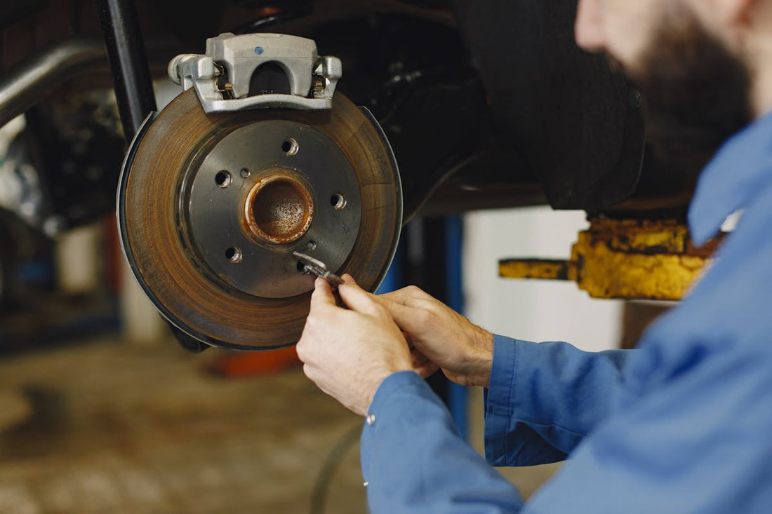 Mechanic replacing the brake rotor and caliper on a car during a brake service