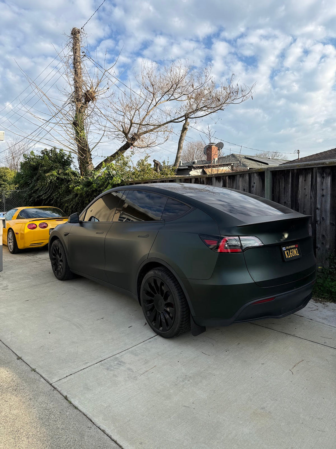 Matte black Tesla Model Y rear three-quarter view parked in a Bay Area driveway, showing rear wheel arch and stance